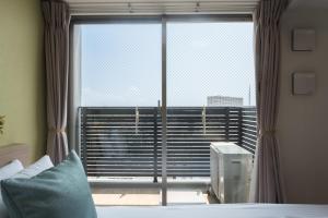 a bedroom with a bed and a large window at ESLEAD HOTEL Namba South Ⅲ in Osaka +33 photos