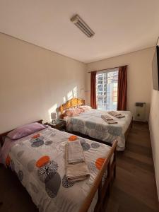 a hotel room with two beds and a window at KAD Alojamiento in Mendoza