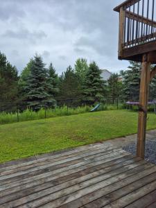 a wooden deck with a playground in the background at Comfortable stay - 2-bedroom apartment in Saint John