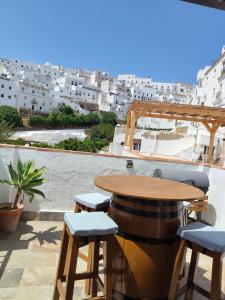 a table and stools on the roof of a building at Loft La Cueva del Niño in Vejer de la Frontera
