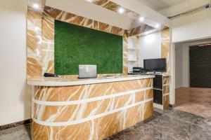 an office with a wooden counter with a green wall at Hotel O White House in Patna