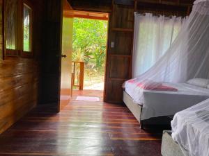 a bedroom with a bed with a mosquito net at Zirumake Tayrona Dentro del Parque Tayrona in El Zaino