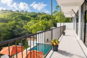 a balcony of a house with a pool and trees at Casa Esperanza in Playa Estacahuite