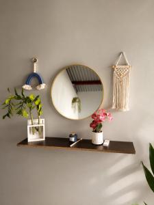 a mirror on a wall with flowers on a shelf at Doña Eneida Cabin in Soná