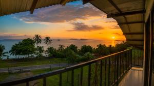 a sunset over the ocean from a balcony of a house at Doña Eneida Cabin in Soná