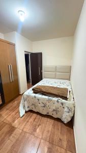 a bedroom with a bed in a room with wooden floors at Apart Serra Azul in Santa Bárbara