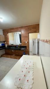 a kitchen with a white table and a refrigerator at Apart Serra Azul in Santa Bárbara +3 photos