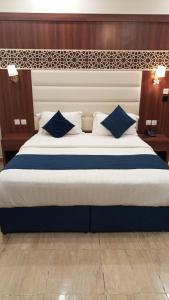 a bedroom with a large bed with blue and white pillows at ALdyar - Al Qunfudhah in Al Qunfudhah