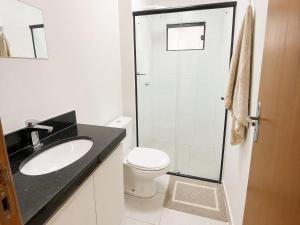 a bathroom with a toilet and a sink and a shower at Apartamento Aconchegante de 02 Quartos in Cuiabá