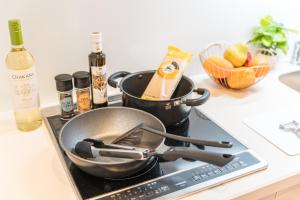 a frying pan on a stove with two pans on it at ESLEAD HOTEL Namba South Ⅲ in Osaka