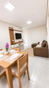 a living room with a table and a couch at Apartamento Aconchegante de 02 Quartos in Cuiabá +5 photos