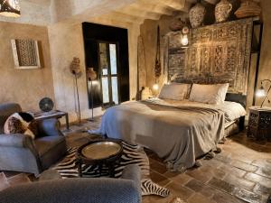 a bedroom with a bed and a couch and chairs at Riad chama in Taroudant +153 photos