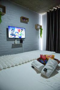 a room with a tv and a bed with towels at The Hideaway Studio-Maboneng in Johannesburg