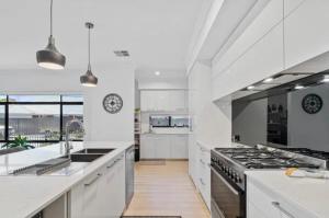 a kitchen with white counters and a stove top oven at Seahawk Escape in Mandurah