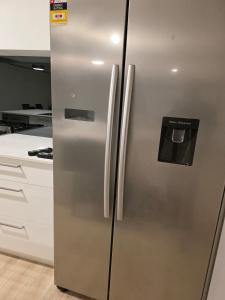 a stainless steel refrigerator in a kitchen at Seahawk Escape in Mandurah +4 photos