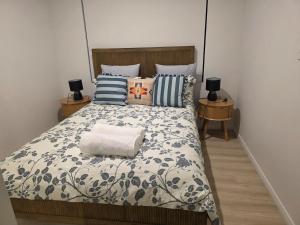 a bedroom with a bed and two night stands with lamps at Seahawk Escape in Mandurah