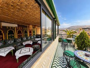 a balcony with tables and chairs on a building at Riad Dar ElBellar in Fez