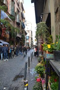un groupe de personnes marchant dans une rue de la ville dans l'établissement Aragonese Luxury Rooms, à Naples