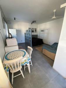 a room with a table and chairs and a bedroom at Loft Da Rosa in Rio Grande