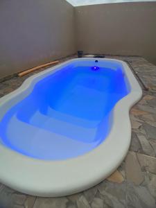 a large white bath tub with blue water in a room at Loft Da Rosa in Rio Grande