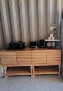 a wooden cabinet with two pots and a microwave on it at Outback Getaway Home in Mount Isa +12 photos