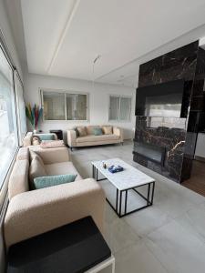 a living room with two couches and a fireplace at Maison dar allouche in Kelibia