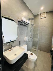 a bathroom with a sink and a shower and a toilet at Saka Hotel in Plei Brel (2) +29 photos