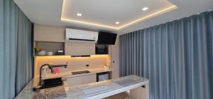 a bathroom with a sink and a counter with a window at Luxtalay Space Capsule in Ban Thung Makham