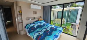 a bedroom with a bed with a view of a balcony at Luxtalay Space Capsule in Ban Thung Makham +19 photos