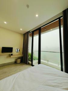 a bedroom with a large bed and a large window at Saka Hotel in Plei Brel (2)