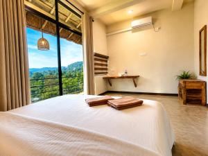 a bedroom with a bed and a large window at Ella Brown House in Ella