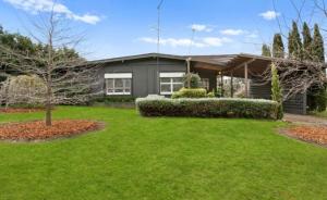 a house with a green lawn in front of it at The Thirlmere Homestead in Thirlmere