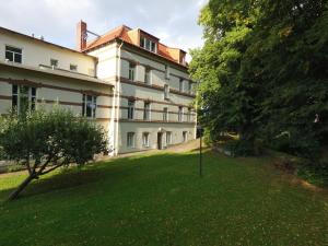 a large white building with a grass yard at MY-BED Hamburg in Hamburg