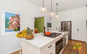 a kitchen with white cabinets and a counter with fruits on it at The Thirlmere Homestead in Thirlmere
