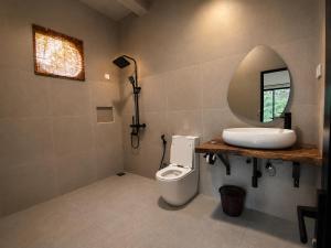 a bathroom with a sink and a toilet and a mirror at Ella Brown House in Ella