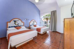 two beds in a room with blue walls at Hotel Mexico Lindo in Santa Cruz Huatulco +49 photos