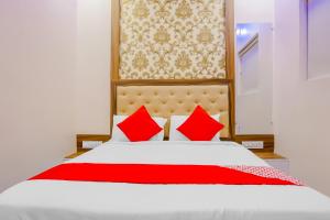 a bedroom with a white bed with red pillows at Hotel O Rest Inn in Yeraoda