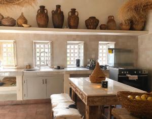 a kitchen with a table and some vases on the wall at Riad chama in Taroudant
