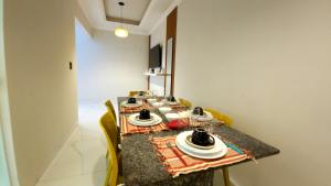 a dining room table with plates and dishes on it at Casa com 3 suítes e piscina privativa no centro de Maragogi perto da praia in Maragogi