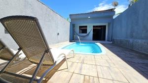 a patio with a chair and a swimming pool at Casa com 3 suítes e piscina privativa no centro de Maragogi perto da praia in Maragogi