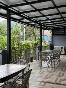a patio with tables and chairs on a deck at Khaosok Secret Hostel in Khao Sok National Park