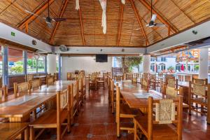 an empty restaurant with wooden tables and chairs at Hotel Mexico Lindo in Santa Cruz Huatulco