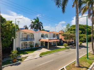 a house on a street with palm trees at Hotel Mexico Lindo in Santa Cruz Huatulco