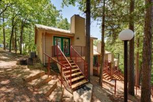 a small house with a staircase in the woods at Ozark Mountain Refuge in Kimberling City
