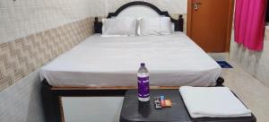 a bedroom with a bed with a bottle on a table at Hotel O VR Lodge in Pathanāmthitta +7 photos