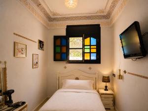 a bedroom with a bed and a stained glass window at Appartement Riad à Taroudant Piscine Privée & Grand Jardin, Séjour Unique in Taroudant