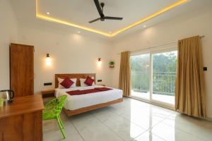 a bedroom with a bed and a desk and a window at Rivendell resort Munnar in Munnar