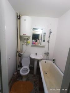 a bathroom with a toilet and a sink and a tub at Gazda ialoveni in Ialoveni