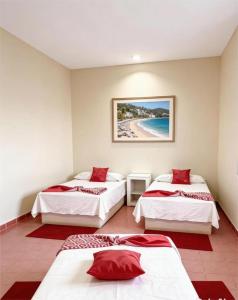 a room with three beds and a beach at Hotel Zihua Malibu in Zihuatanejo +17 photos