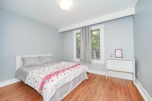 a white bedroom with a bed and a window at Finch Terminal Station 1min -Yonge and Finch Intersection in Toronto